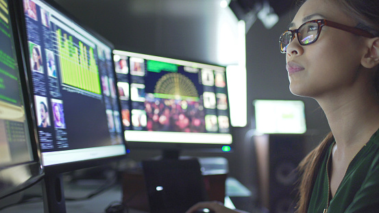 Employee studying data on computer screens